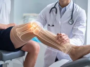 Orthopedic doctor in white coat examining patient's knee with skeletal X-ray overlay showing bone structure